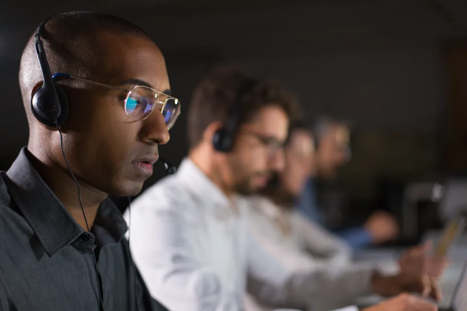 A business support professional using a headset at a computer